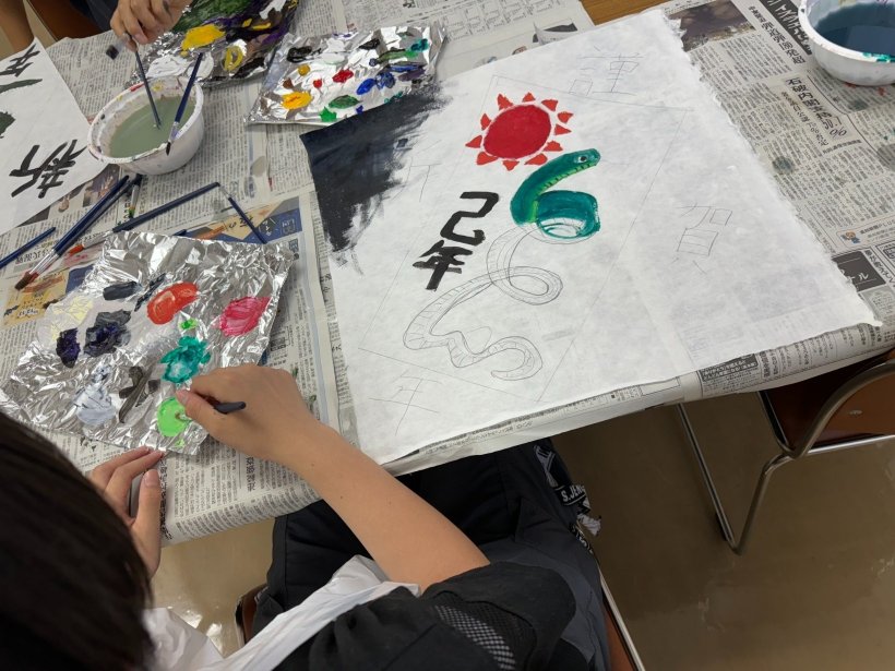 アルミの上で色の調合している、色のついた和紙